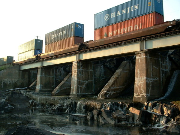 A freight train going over a bridge on top of a dam