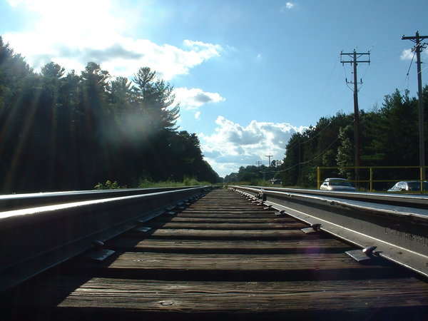 A photograph of the train tracks on the bridge crossing over the larger, primary dam